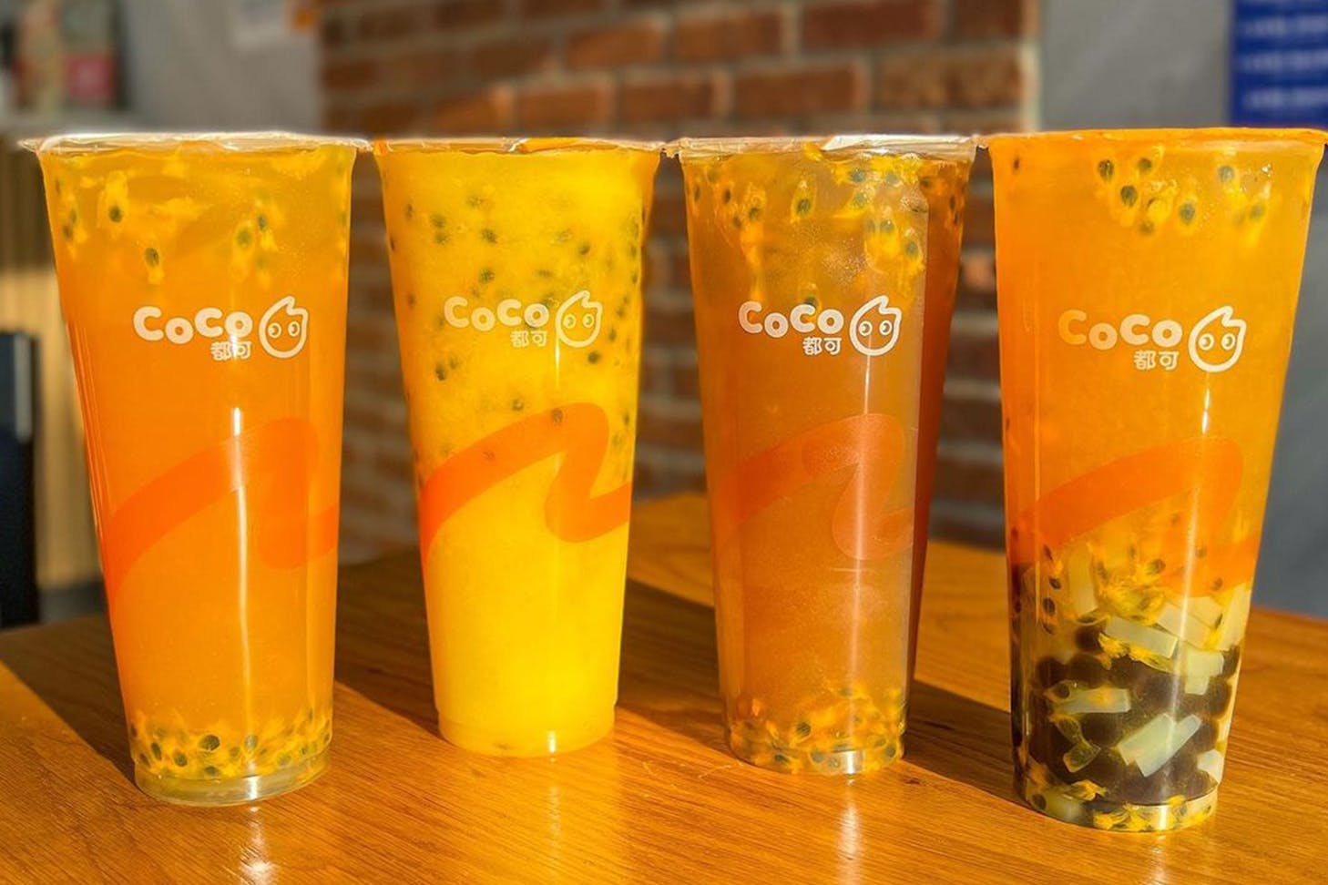 four bubble tea lined up on a shelf